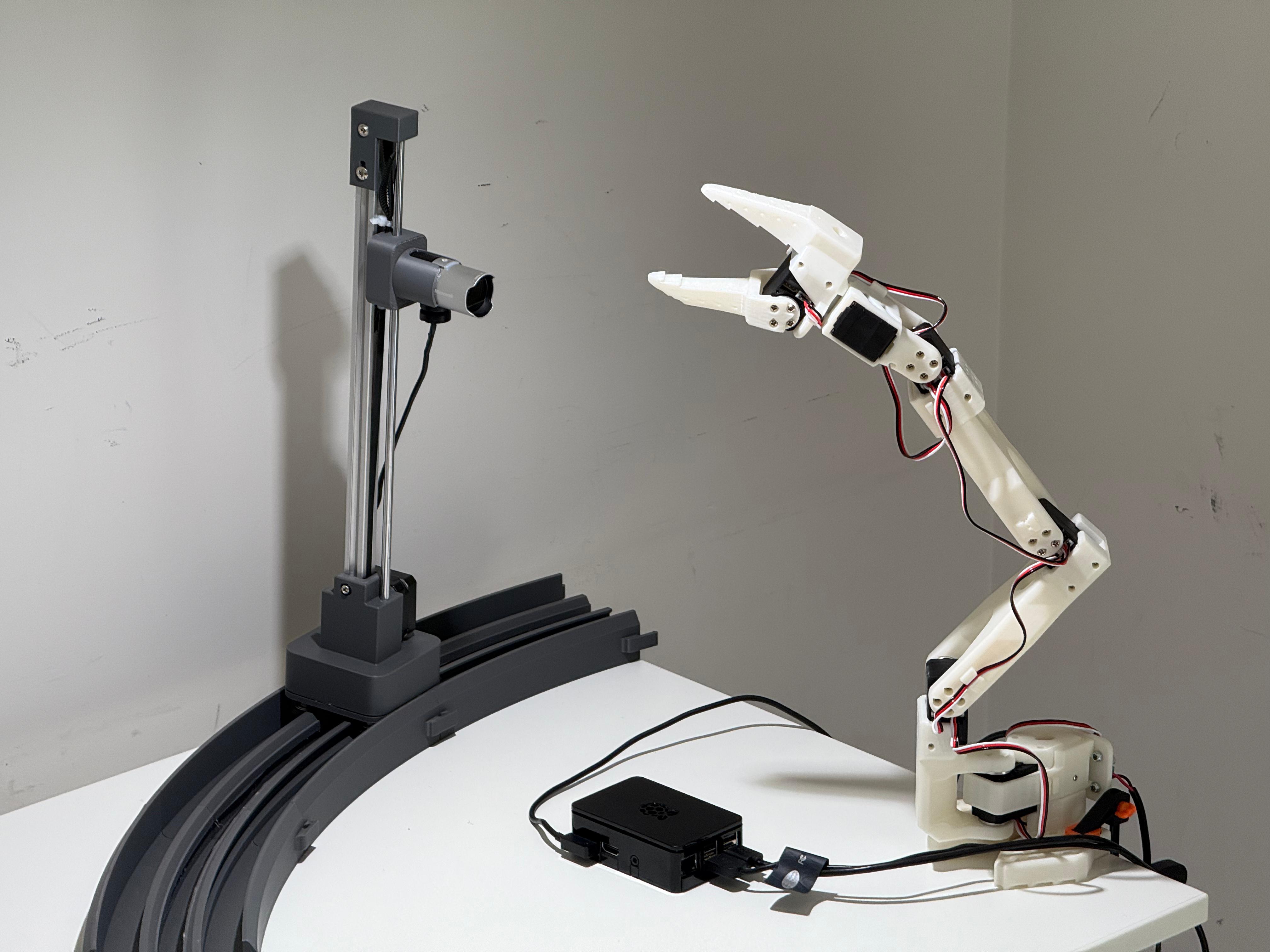 The full rig: SO-ARM101, motorized camera on curved rail, Raspberry Pi